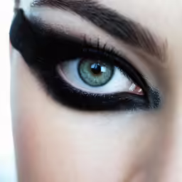 an extreme close up of blue and black eye makeup