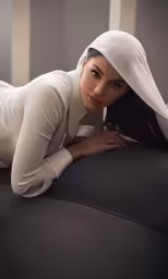 a beautiful young woman lying on the top of a chair
