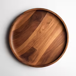 the brown wood plate is on a white surface