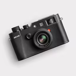 an old black camera with a lens in front of it