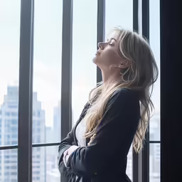an attractive woman posing in front of window sills