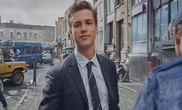 young man with black and white tie standing on street corner