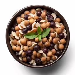 a bowl filled with nuts and olives next to a leaf