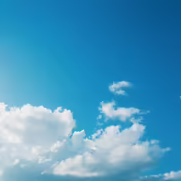 a plane flying through a cloudy blue sky