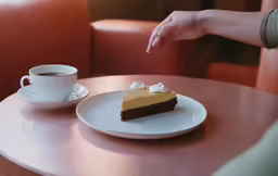 a slice of pie on a plate with coffee