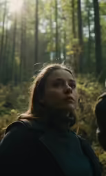 a beautiful young woman in the woods staring off to the side