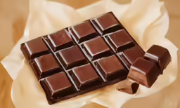 there is a square chocolate bar on top of wax paper