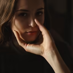 a woman poses for a picture with her hand on the side of her face