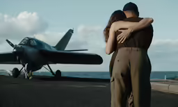 a man is hugging his wife by the propeller of an airplane