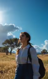a beautiful woman in a white blouse standing in a field