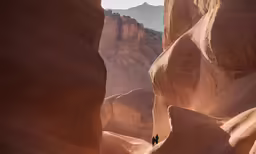 a man walks through some large, rock canyon