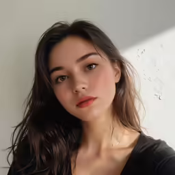 a young woman standing in front of a white wall