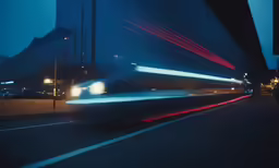 cars passing by on a city street at night