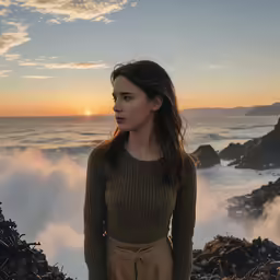 young woman standing on rocky beach during sunset