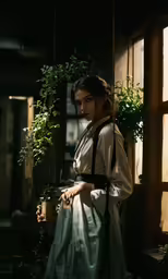 woman wearing dress and suspenders leaning up against a wall