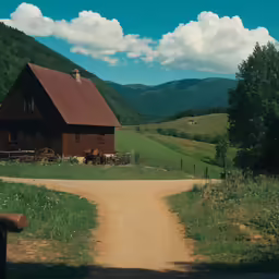 a wooden barn next to a dirt road