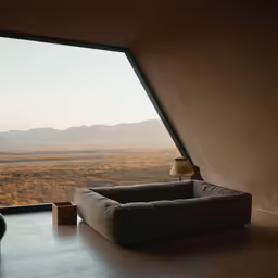 a modern looking couch is by an open window