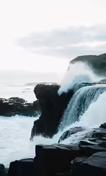 the water is spraying out from the rocks