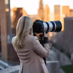 a woman taking a photo with a large camera