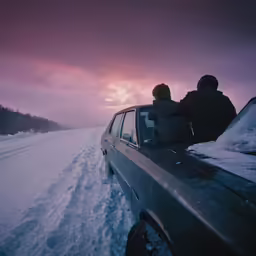 a couple of people sitting in the back of a car