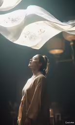 a woman stands beneath the flowing white material