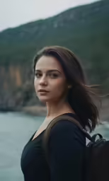 a beautiful woman standing next to a large body of water