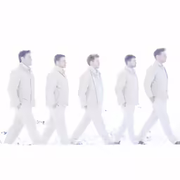 a man in a suit walking along the snow