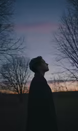 a man looks upward at the night sky