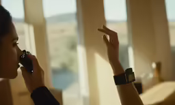a girl is using her cellphone and pointing