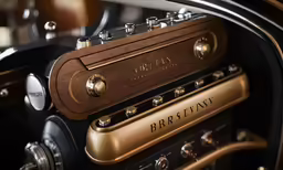 an antique car engine with brass trim and wood