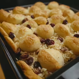 a tray filled with rolls topped with cranberries and raisins