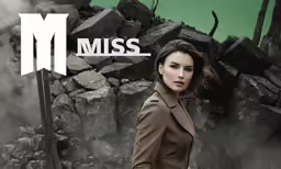 an attractive lady standing in front of a pile of rocks