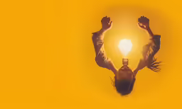 the girl is upside down and has a lightbulb in her hand