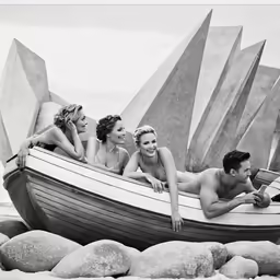 black and white photo of people in a boat at the beach