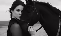 a woman posing next to a horse in the field