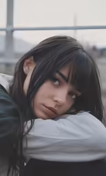 a girl with black hair wearing a grey shirt