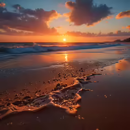 a close up of a beach with waves coming into shore