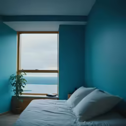 a bed with white sheets and a potted plant