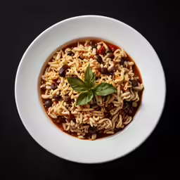 a bowl of pasta with black beans and basil