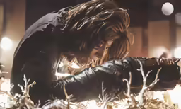 a person in a leather jacket reaching to touch something
