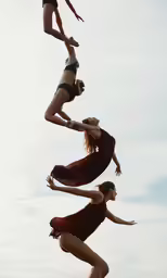 three women are in mid air in bathing suits