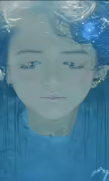 a girl with long hair in the water is staring
