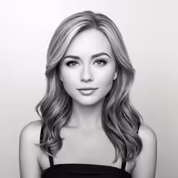 a beautiful woman in black top posing with her hair curled up and looking at the camera