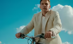 a man in a suit riding his bike