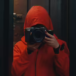 someone in a hooded robe is taking a photo