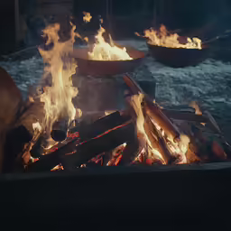 this is a fire with several bowls full of firewood