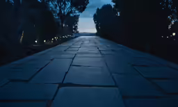 a dark empty street has lights on both sides