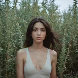 a girl with very thin breast standing in a tall grass field