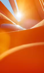 an abstract image of an orange building with the sun shining through the roof