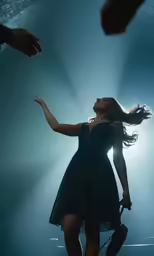 the young woman in a dress is dancing on stage
